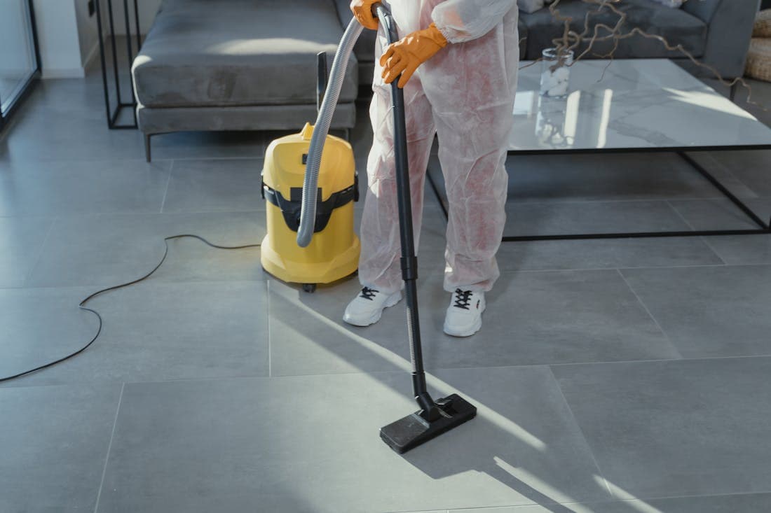 A professional cleaner vacuuming a living room